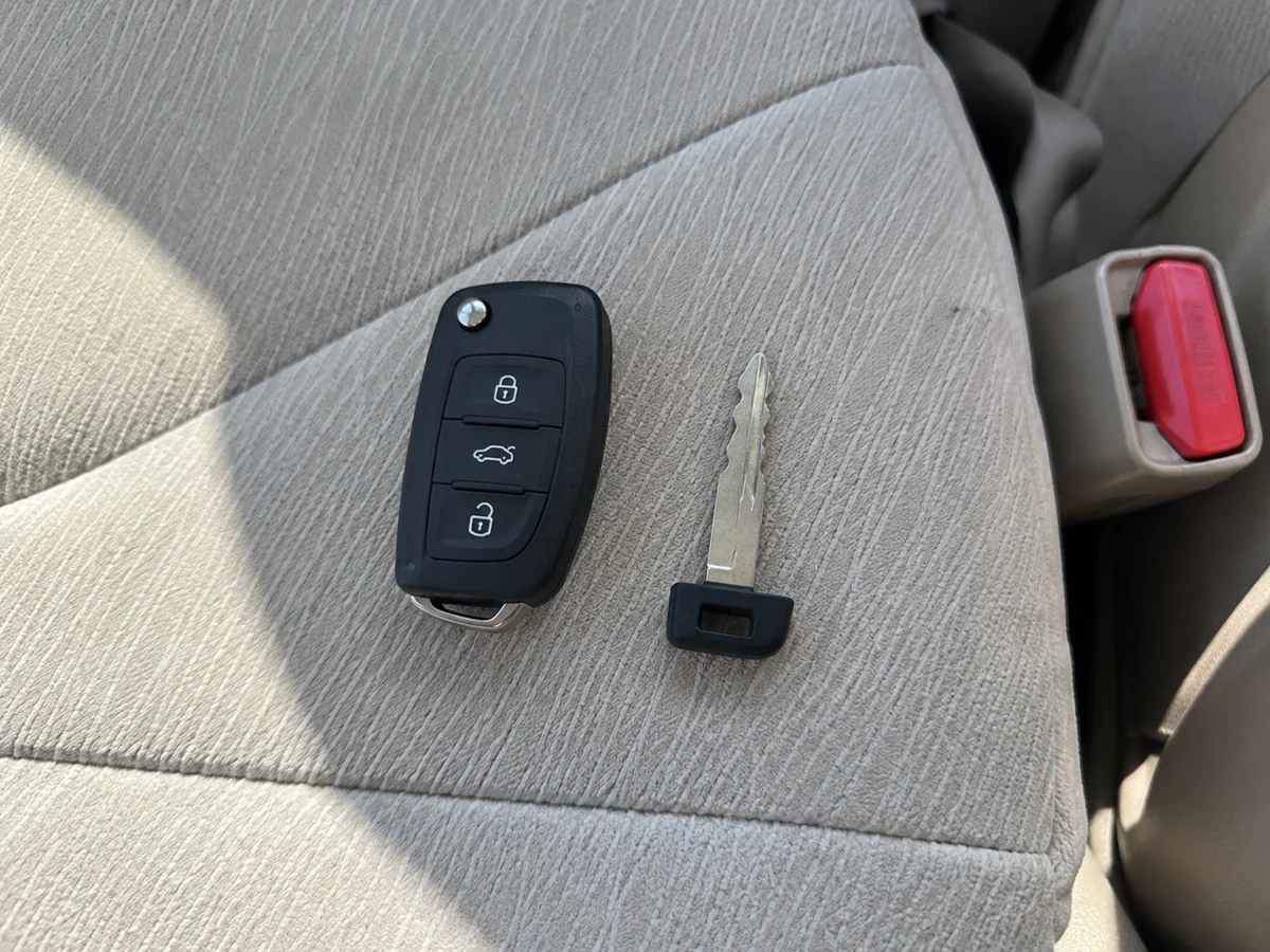Black key fob and emergency key on a light fabric seat