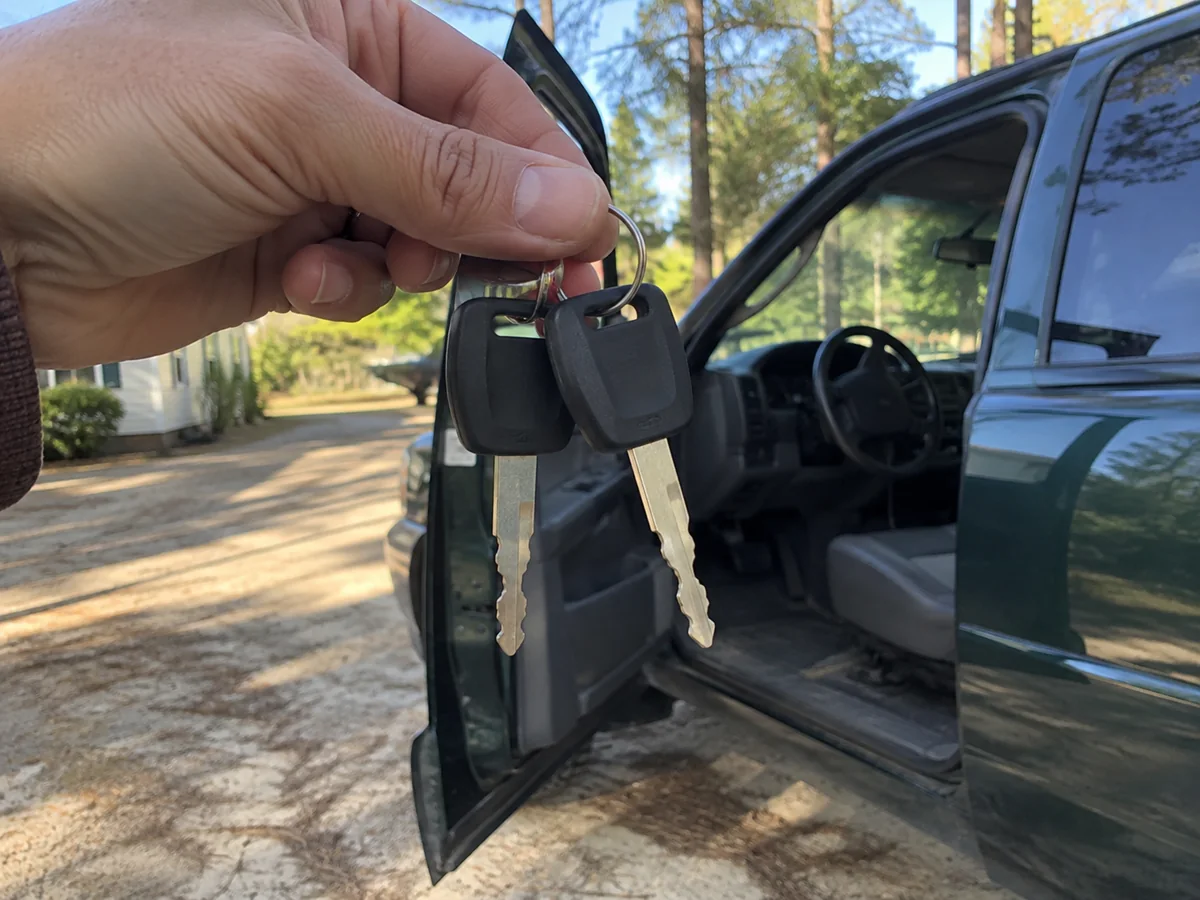 Two spare transponder keys beside a green pickup truck