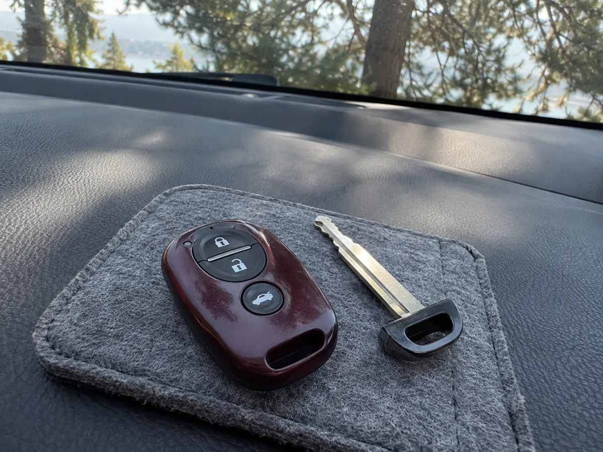 Burgundy remote and emergency blade on a felt pouch